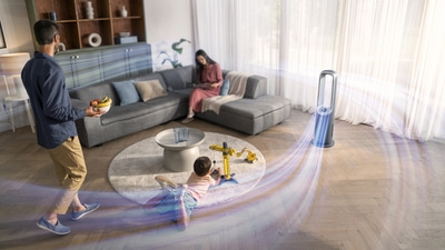 Familie im Wohnzimmer mit Ventilator, Kind spielt, Frau liest, Mann trägt Obst.